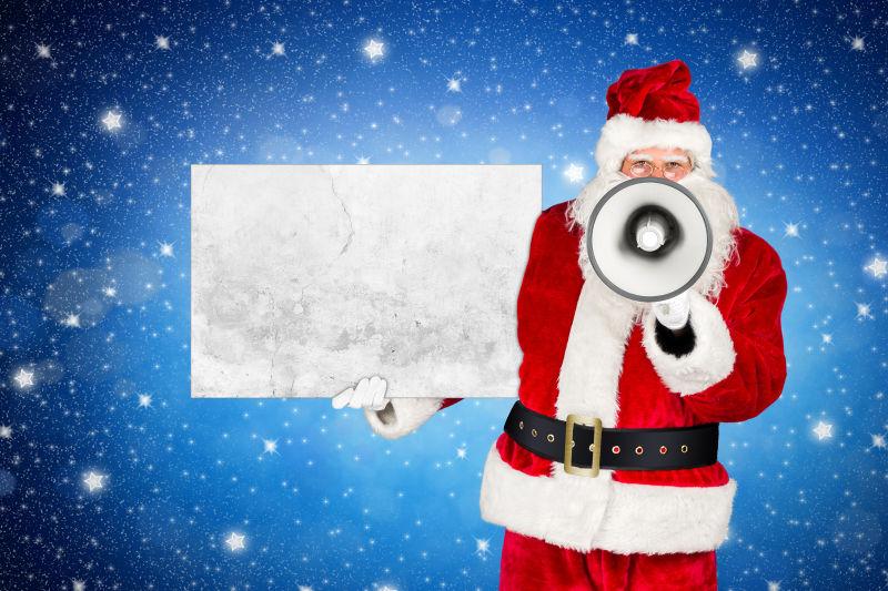 圣诞老人用扩音器拿着空空的混凝土广告牌
