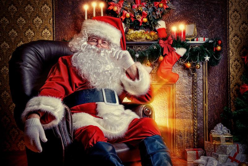 圣诞老人带着圣诞礼物做在椅子上