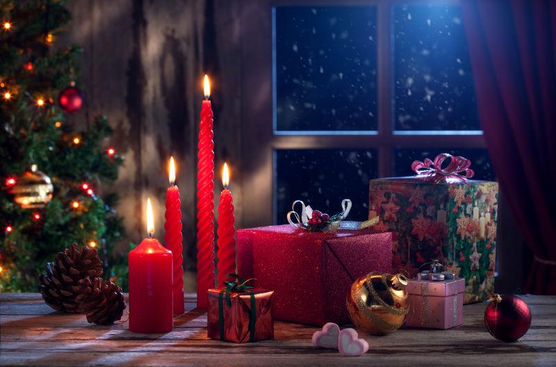 夜色下房间里点燃的红蜡烛和各种圣诞礼物还有各种圣诞装饰物