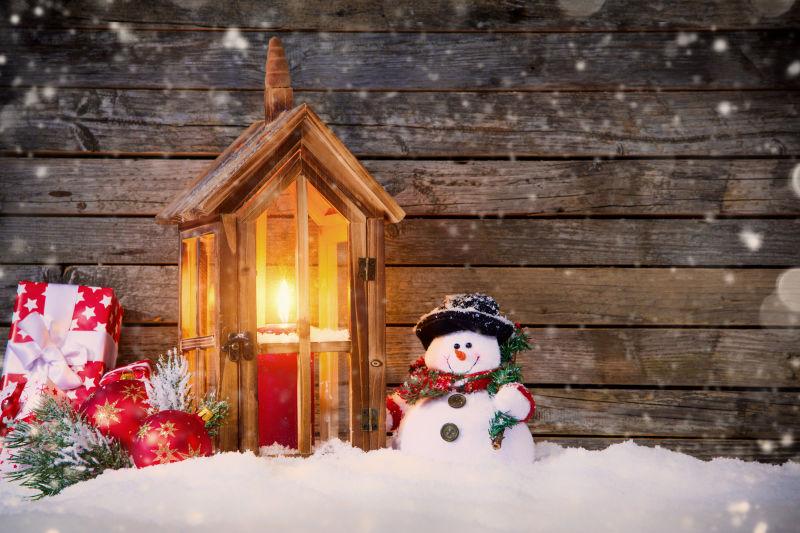 油灯边的小雪人和圣诞礼物还有两个红色铃铛