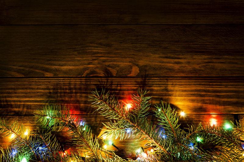 木墙下闪烁着各种灯光的美丽圣诞树