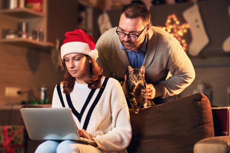 男人和戴着圣诞帽的美女看笔记本电脑