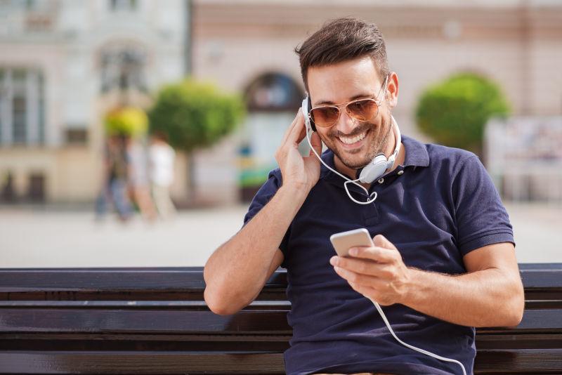 街头听音乐玩手机的男人