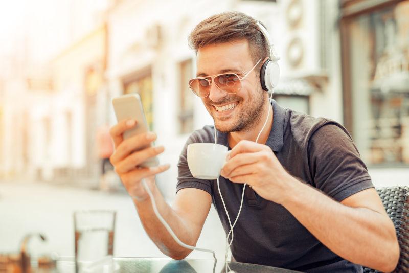 玩手机听音乐喝咖啡享受的男人