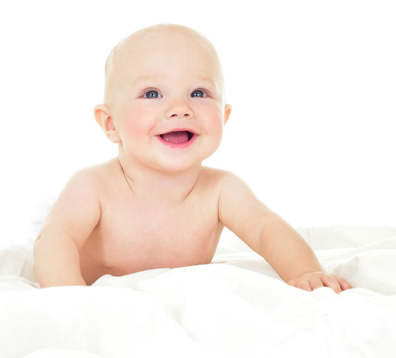 微笑婴儿趴在白色床上