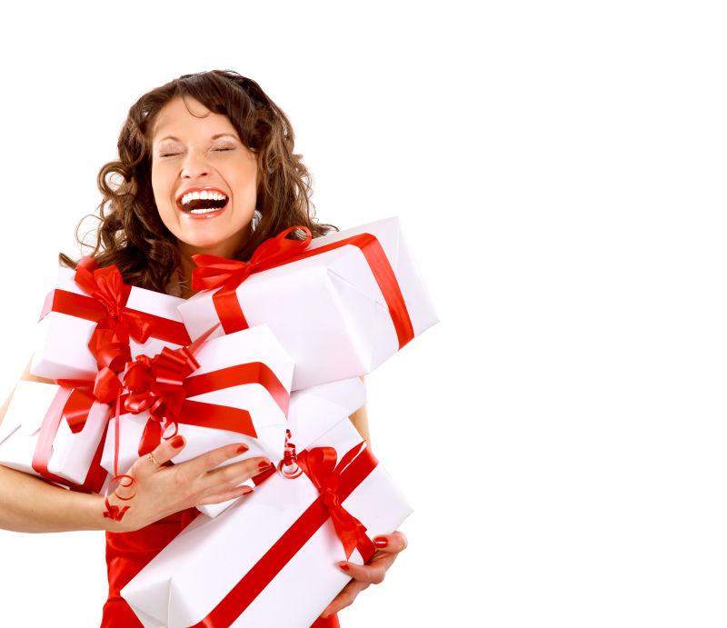 白色背景下抱着礼物开怀大笑的女人