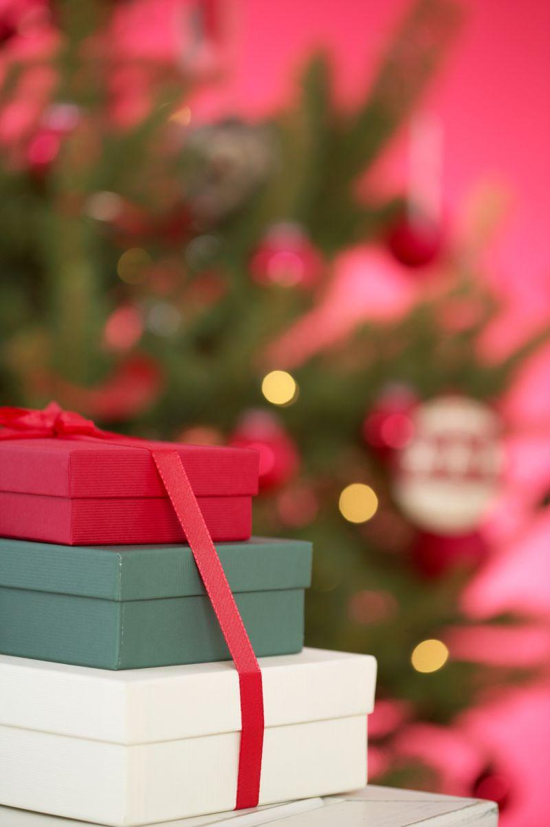 圣诞树边的三个不同颜色的礼物盒