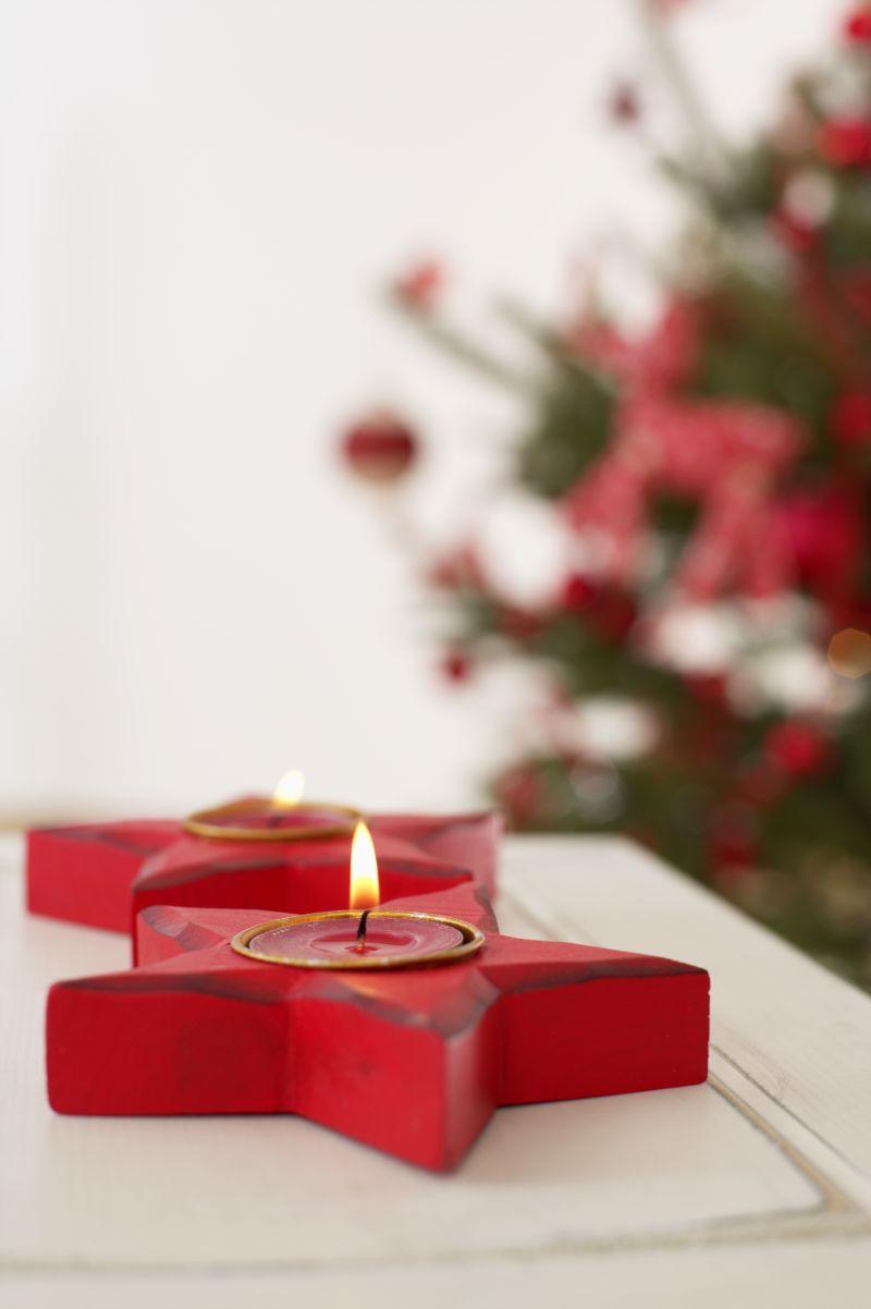 圣诞树边桌子上的红色星形蜡烛