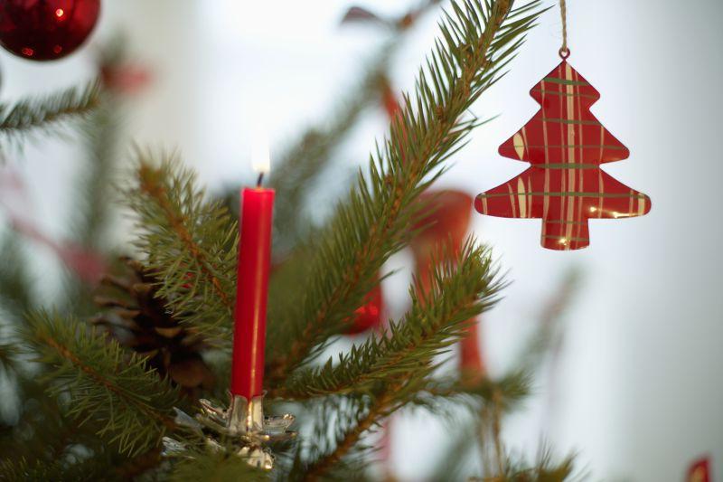 圣诞树上的蜡烛和布制的红色圣诞树装饰