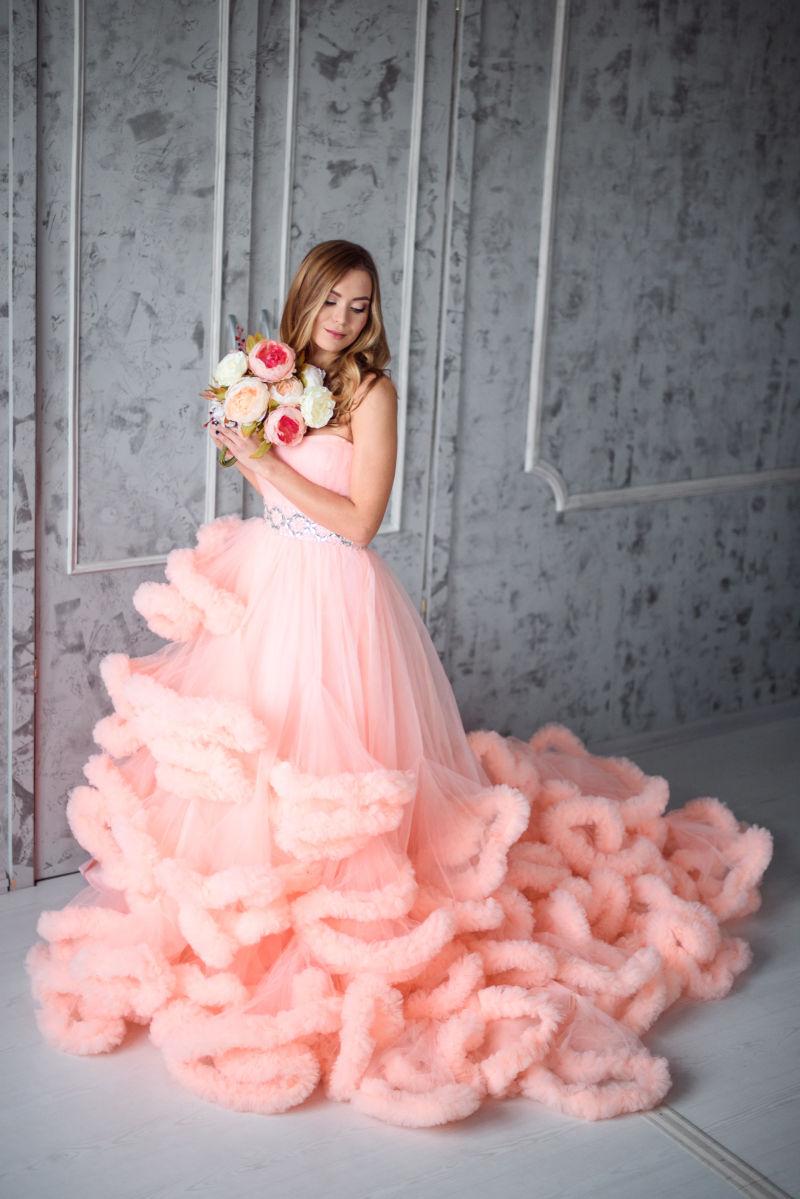 穿着粉色婚纱的美女拿着花束