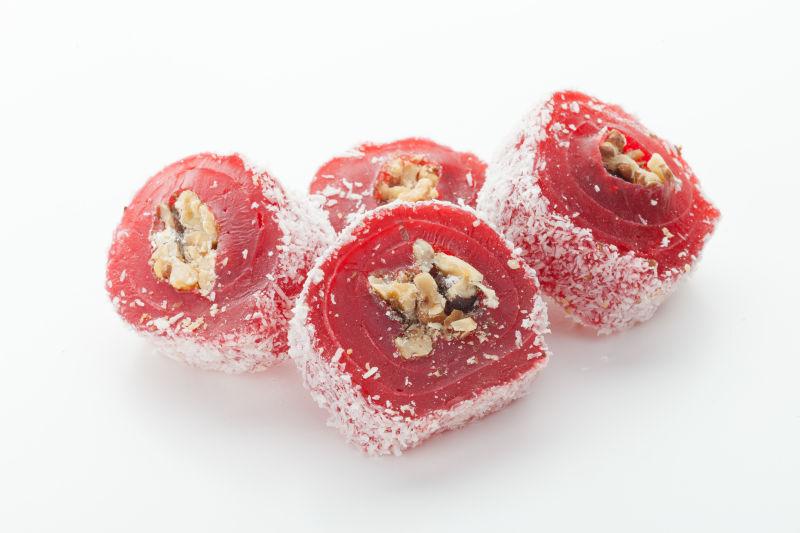 白色桌上美味的红色带有干果馅料的土耳其软糖