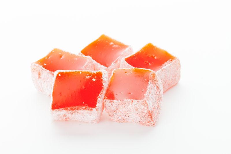 白色背景上美味的红色水晶状土耳其软糖