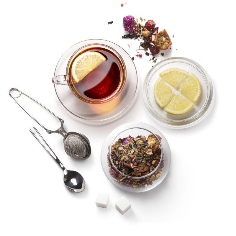 白色背景上的红茶和柠檬还有各种泡茶工具 