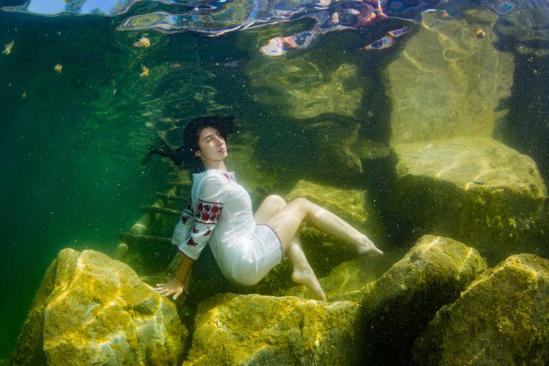 穿着乌克兰刺绣在水下装扮的年轻优雅的女子