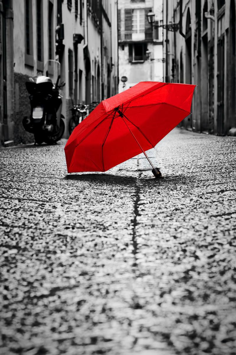 旧镇鹅卵石街上的红色雨伞