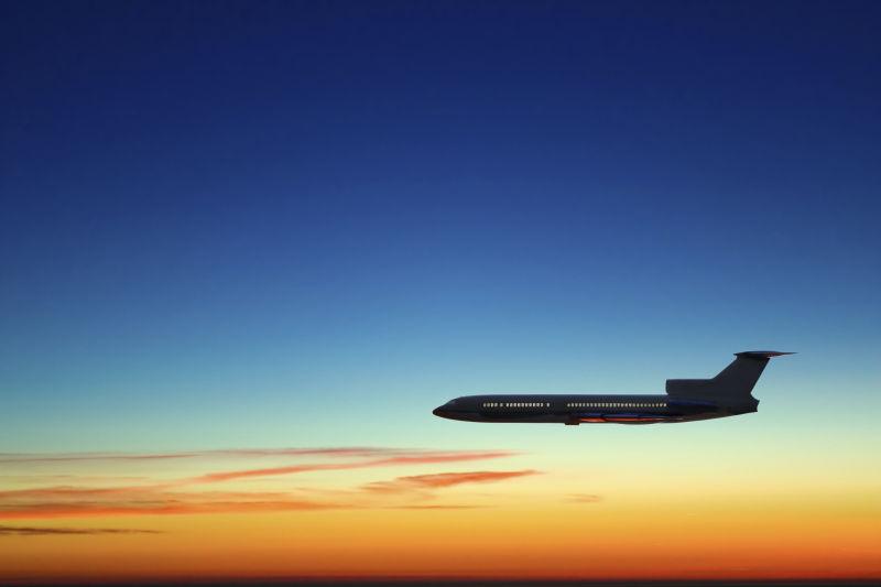 夕阳下正在飞行的飞机