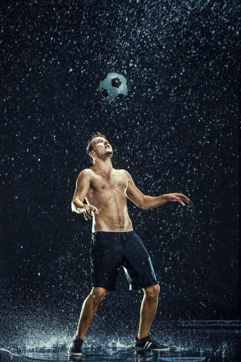 黑色背景下水滴在足球运动员周围