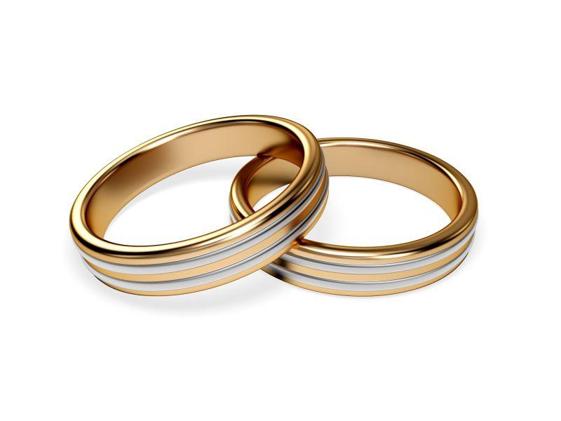 白色背景下的一对金结婚戒指