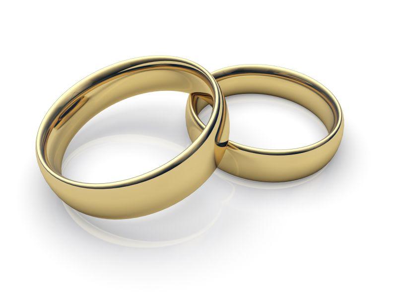 白色背景下靠在一起的金色结婚戒指