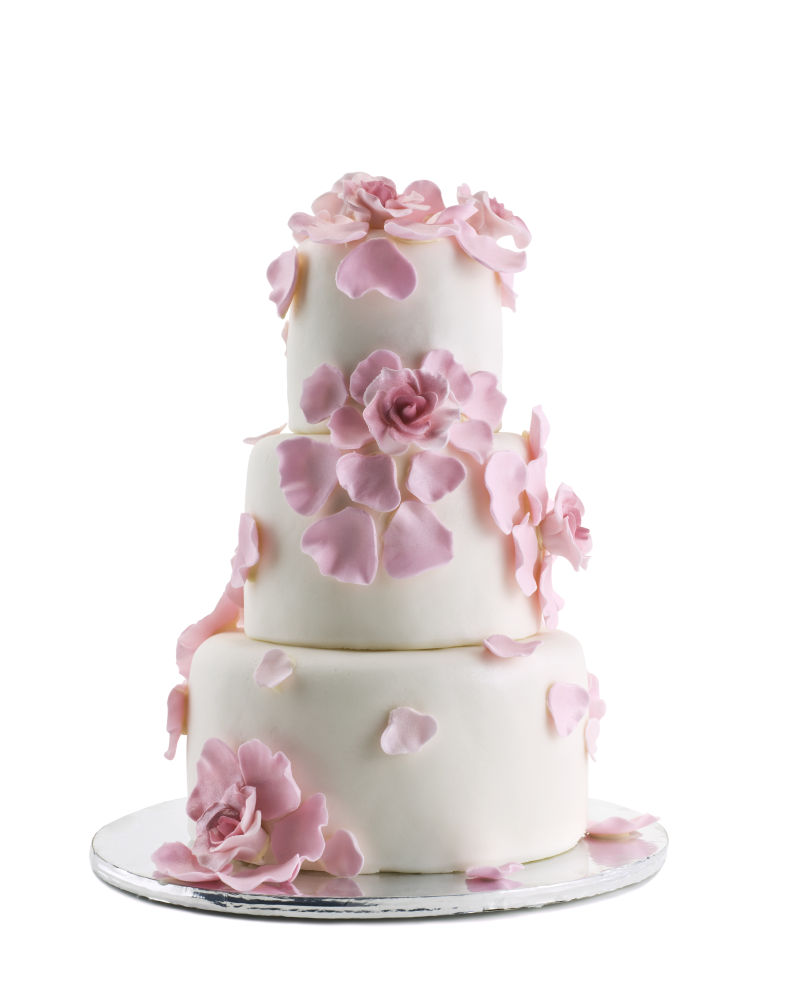 白色背景前粘满花瓣的生日蛋糕