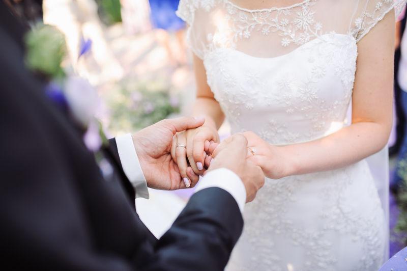 新娘和新郎手上戴着结婚戒指