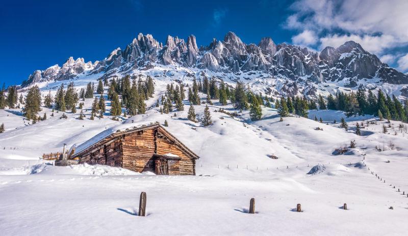冰雪覆盖的阿尔卑斯山山底的小木屋