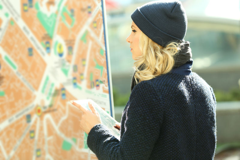 戴着帽子的年轻女性看着城市地图