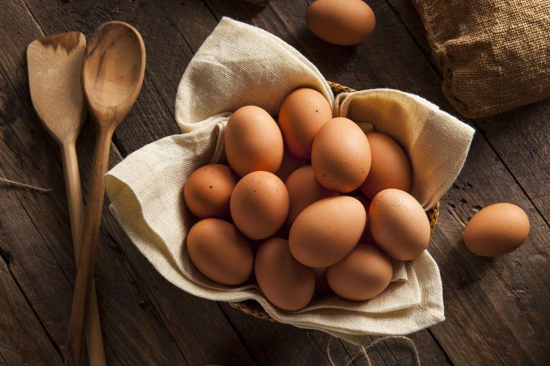 木桌上的一堆鸡蛋和木勺