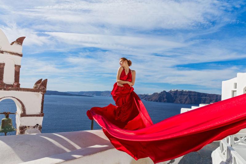 圣托里尼岛上穿着红色长裙的美女