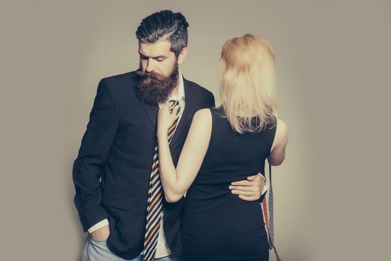 英俊的胡须男人和他的女友在挑选领带