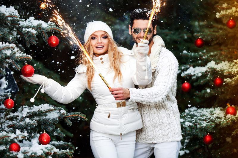 挂满装饰的圣诞树下的白衣夫妇