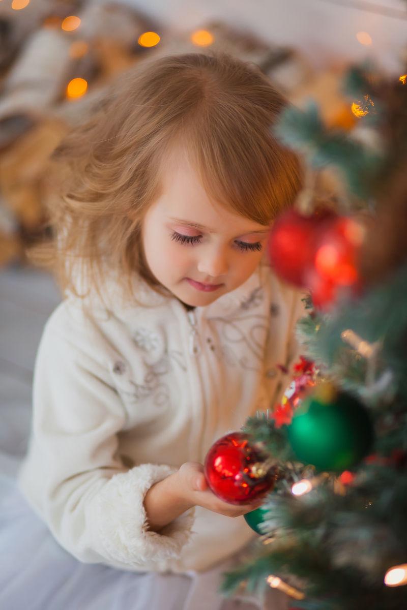 圣诞树旁边可爱的金发小美女