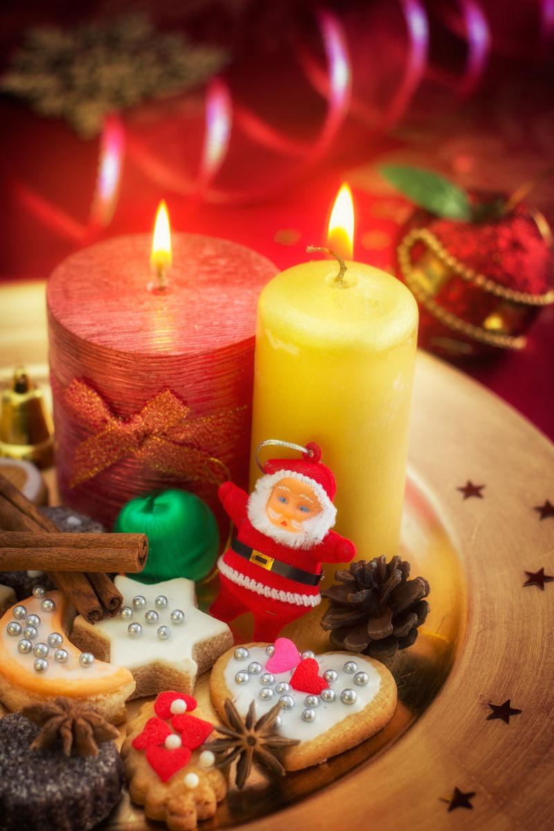 点燃的蜡烛盘的各种可爱的圣诞饰品