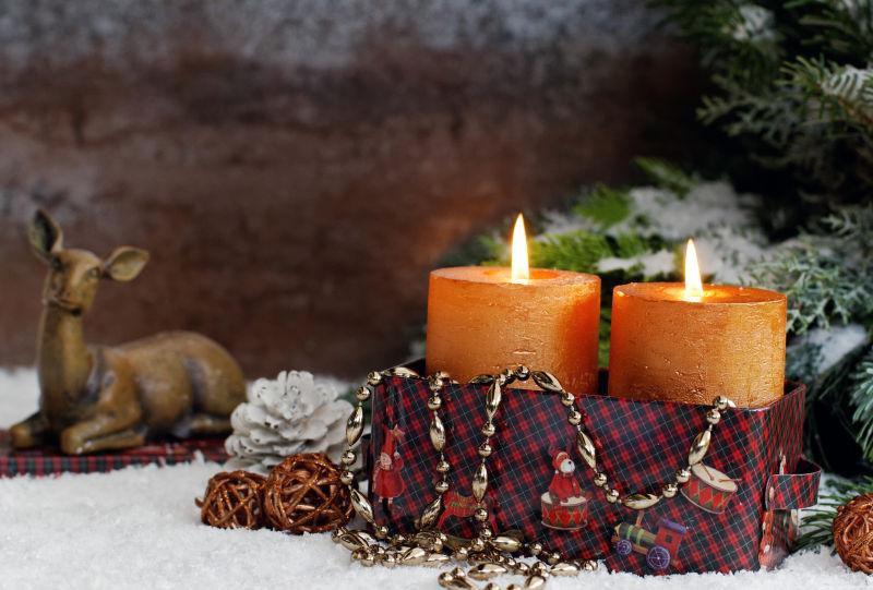 圣诞节小鹿装饰品与燃烧的蜡烛