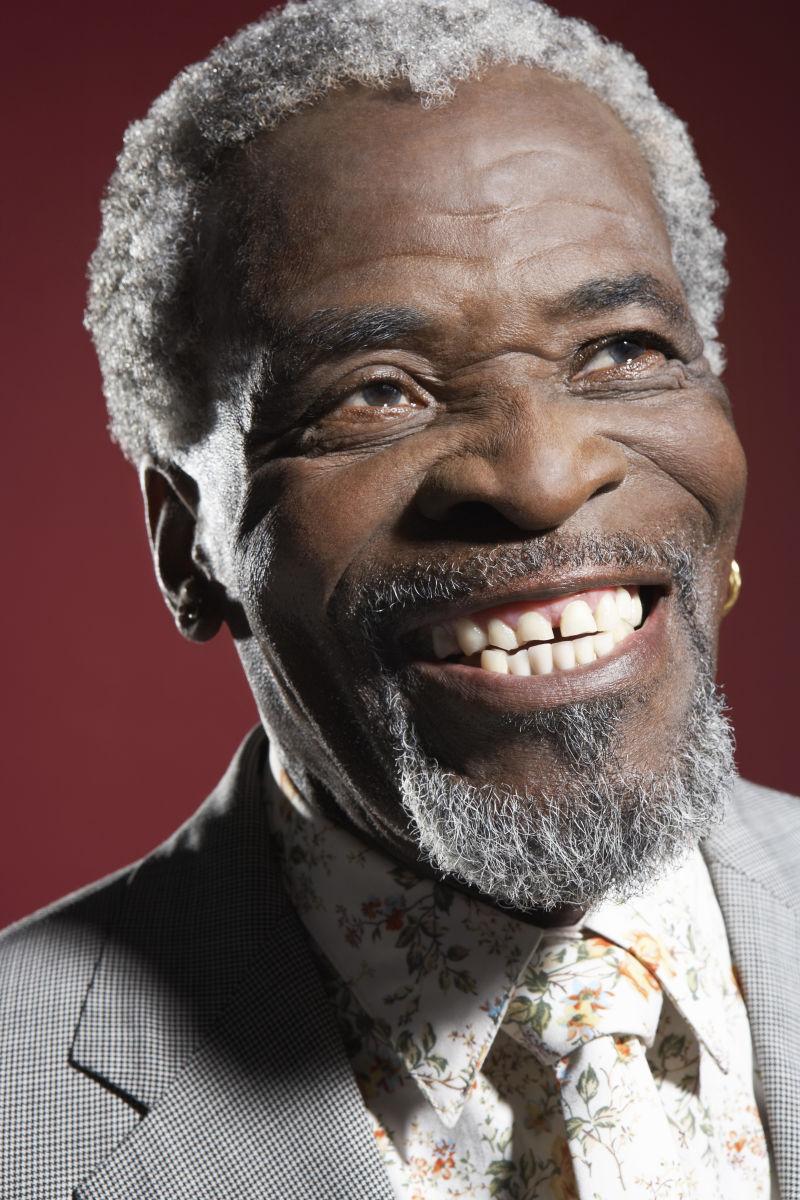 一位非洲裔美国人微笑面对红色背景的特写镜头