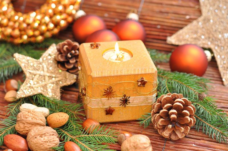 木桌上的各种圣诞节饰品和点燃的蜡烛