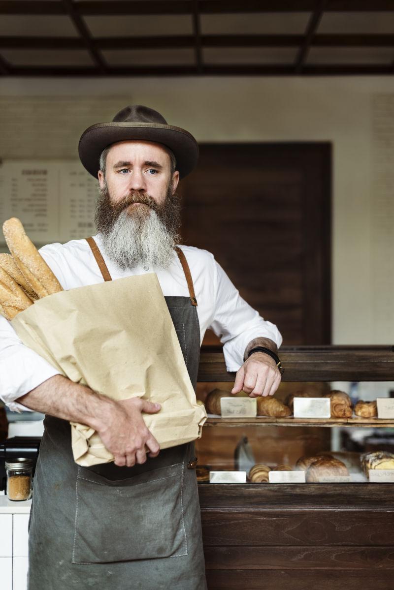 咖啡馆里抱着一袋面包的男子