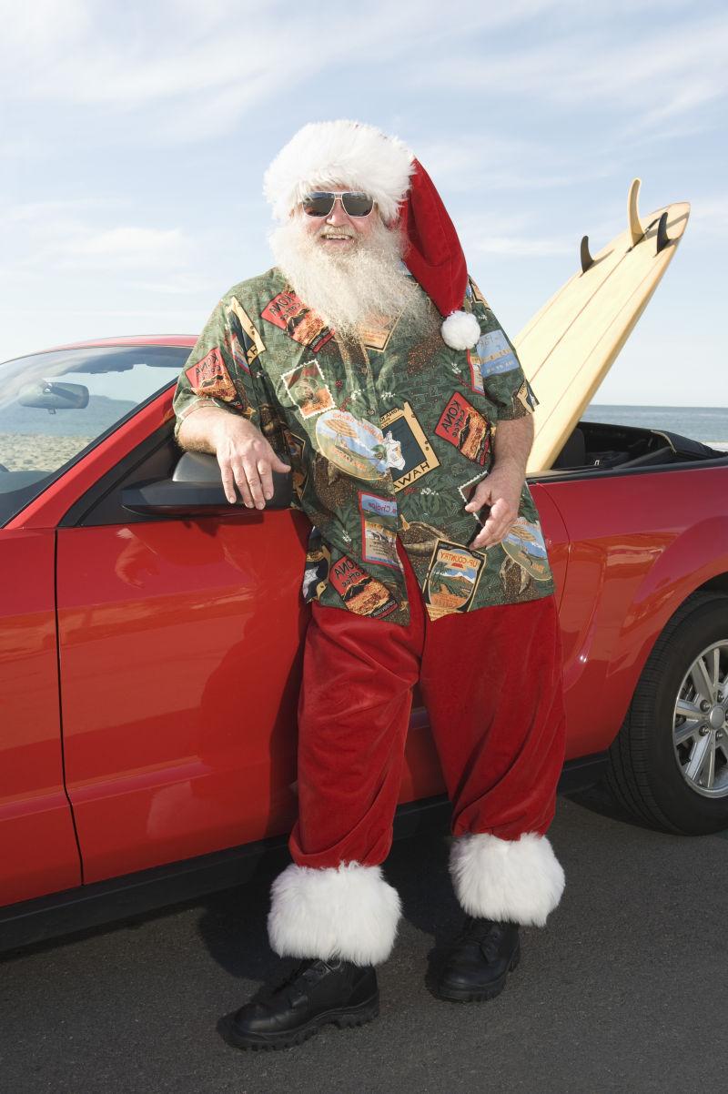 靠在红色跑车上的圣诞老人