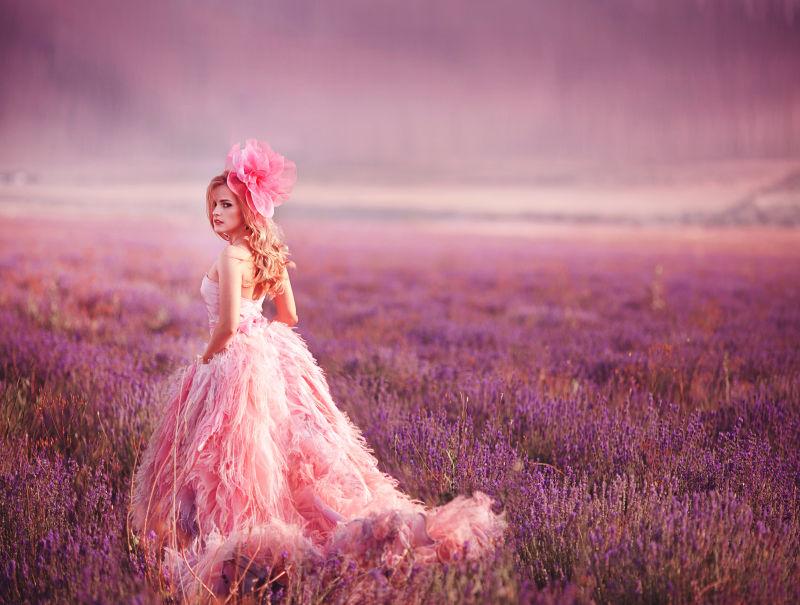 薰衣草园里穿着粉色长裙戴着粉色花朵的美女