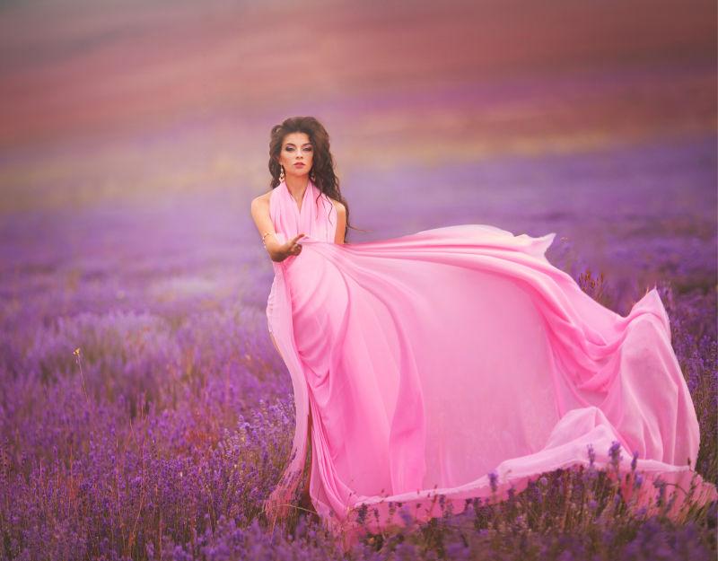 夕阳下薰衣草园里穿着粉色长裙撒开裙摆的美女