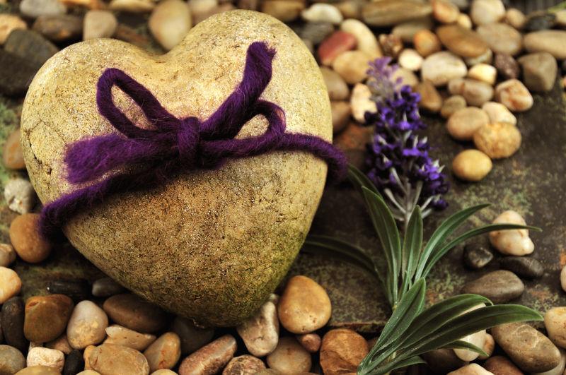 紫色丝带装饰的心形石头