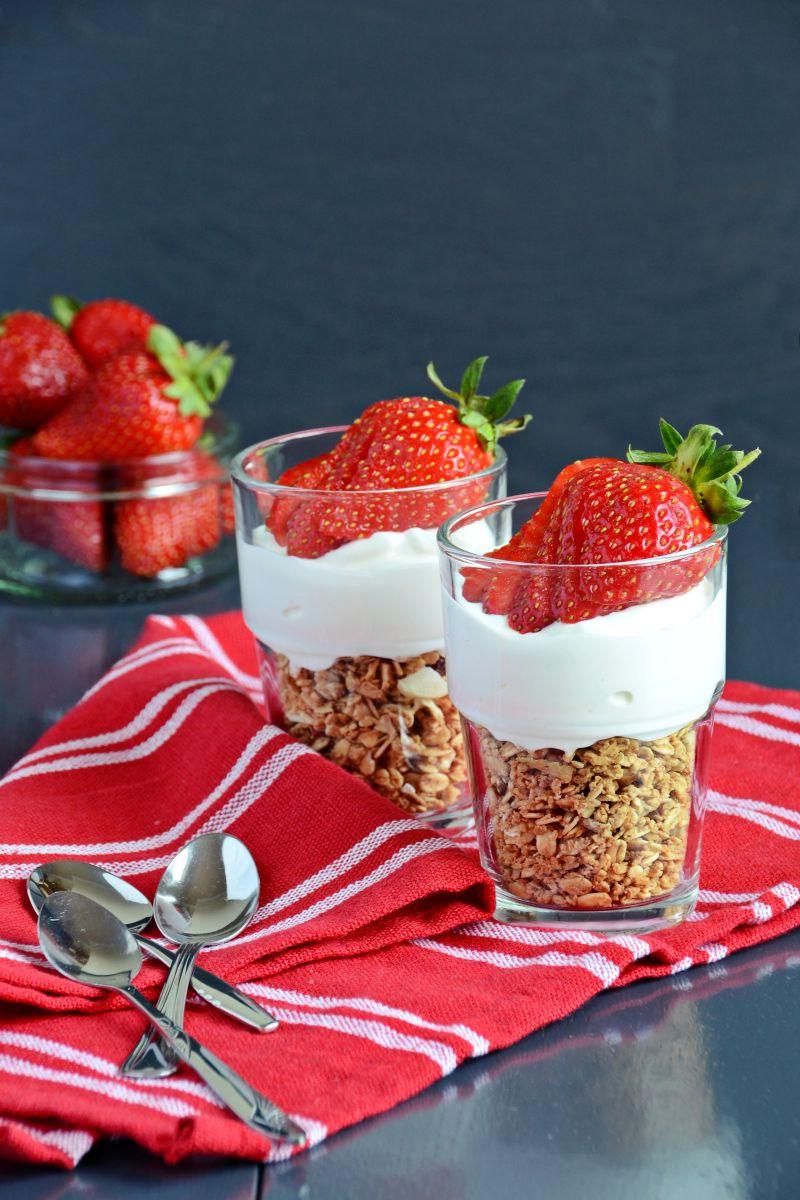 红色桌布上的两杯草莓酸奶燕麦早餐