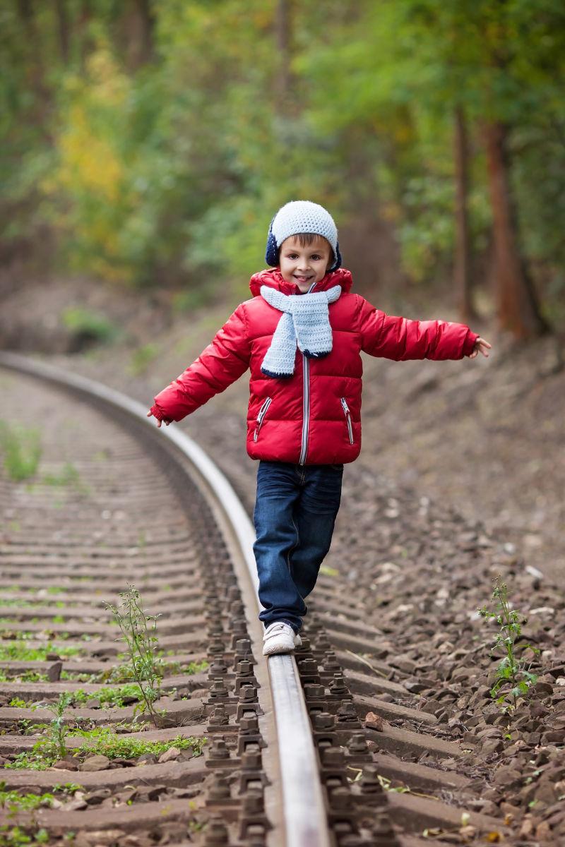 可爱的男孩走在铁路上