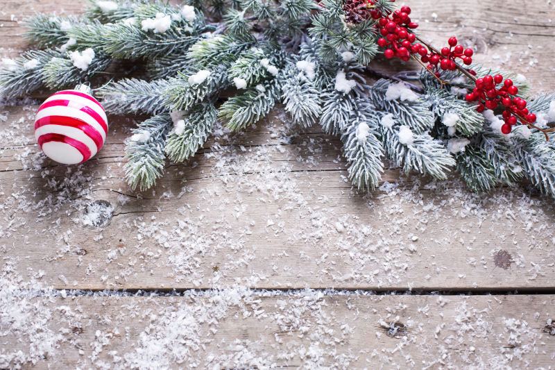 木板上的圣诞树枝还有野生浆果还有可爱的铃铛
