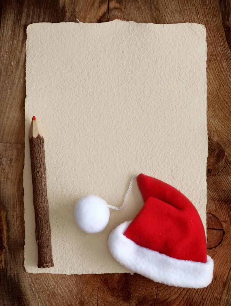 旧羊皮纸上的木质铅笔和红色圣诞帽