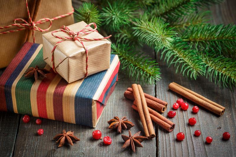 木质背景上带装饰的圣诞礼品盒与云杉树枝