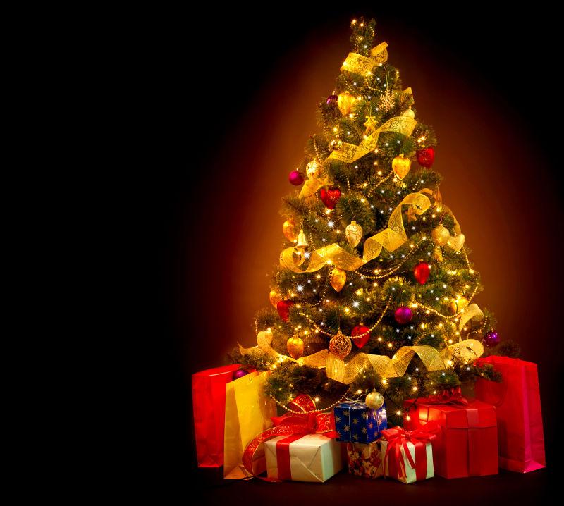 黑色背景下的礼物和圣诞树