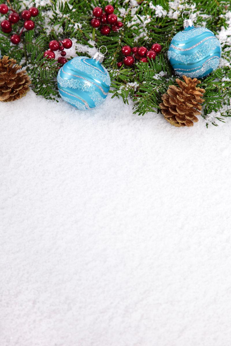 雪上的圣诞树装饰品和松果