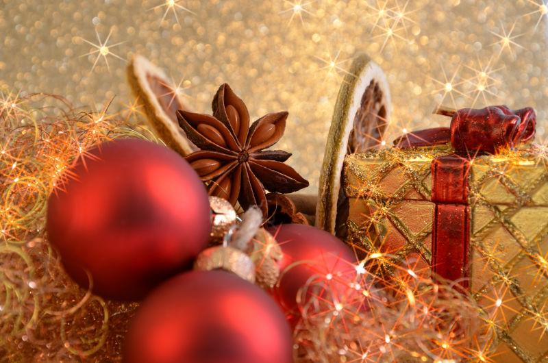 金色背景下的金色的礼品盒和红色的圣诞球