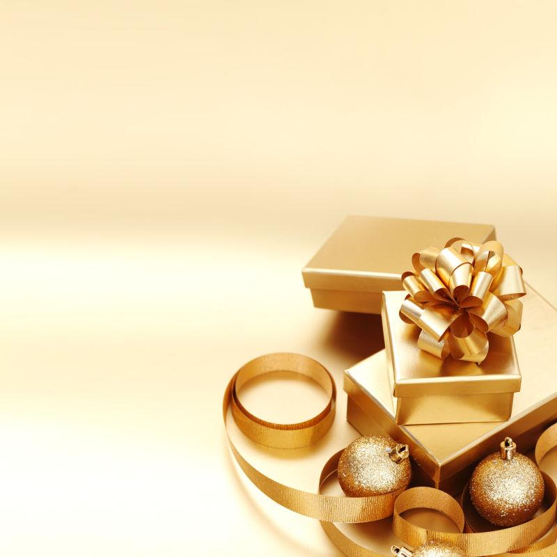 金色背景上的金色的礼品盒和装饰品